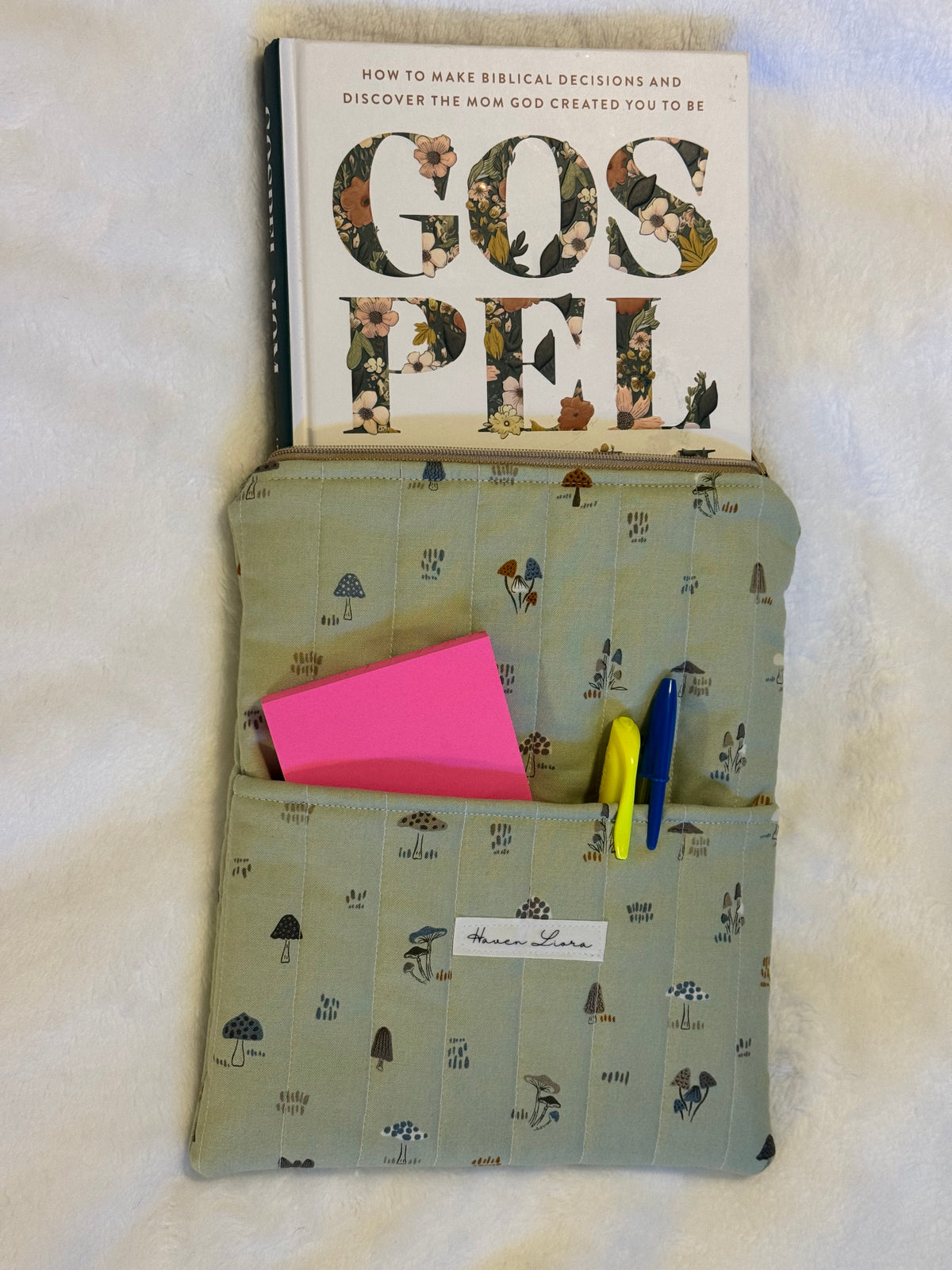Mossy Mushroom Kindle Sleeve exterior in sage green mushroom print with front pocket holding sticky notes and pens