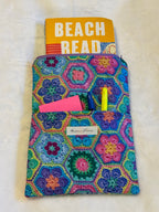 Crochet Garden Paperback Sleeve exterior showing vibrant jewel-tone granny square print in purples, teals, pinks and yellows with front pocket and purple zipper