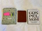 Mossy Mushroom Kindle Sleeve shown open alongside a small Bible and paperback book for size comparison