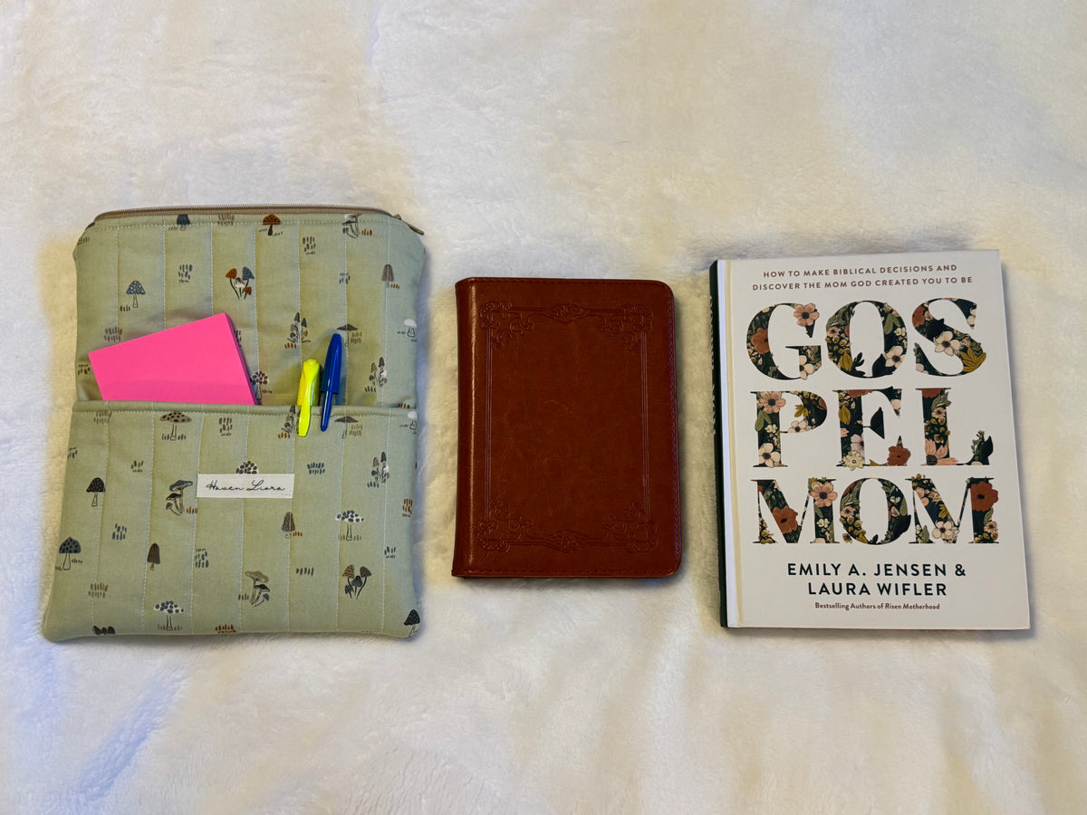 Mossy Mushroom Kindle Sleeve shown open alongside a small Bible and paperback book for size comparison