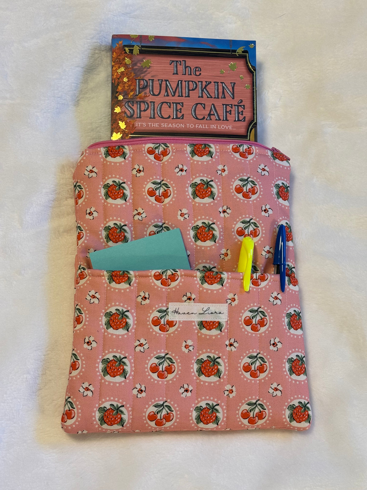 Sweet Cherry Pie Pink Kindle Sleeve exterior in pink strawberry and cherry print with front pocket holding sticky notes and pens