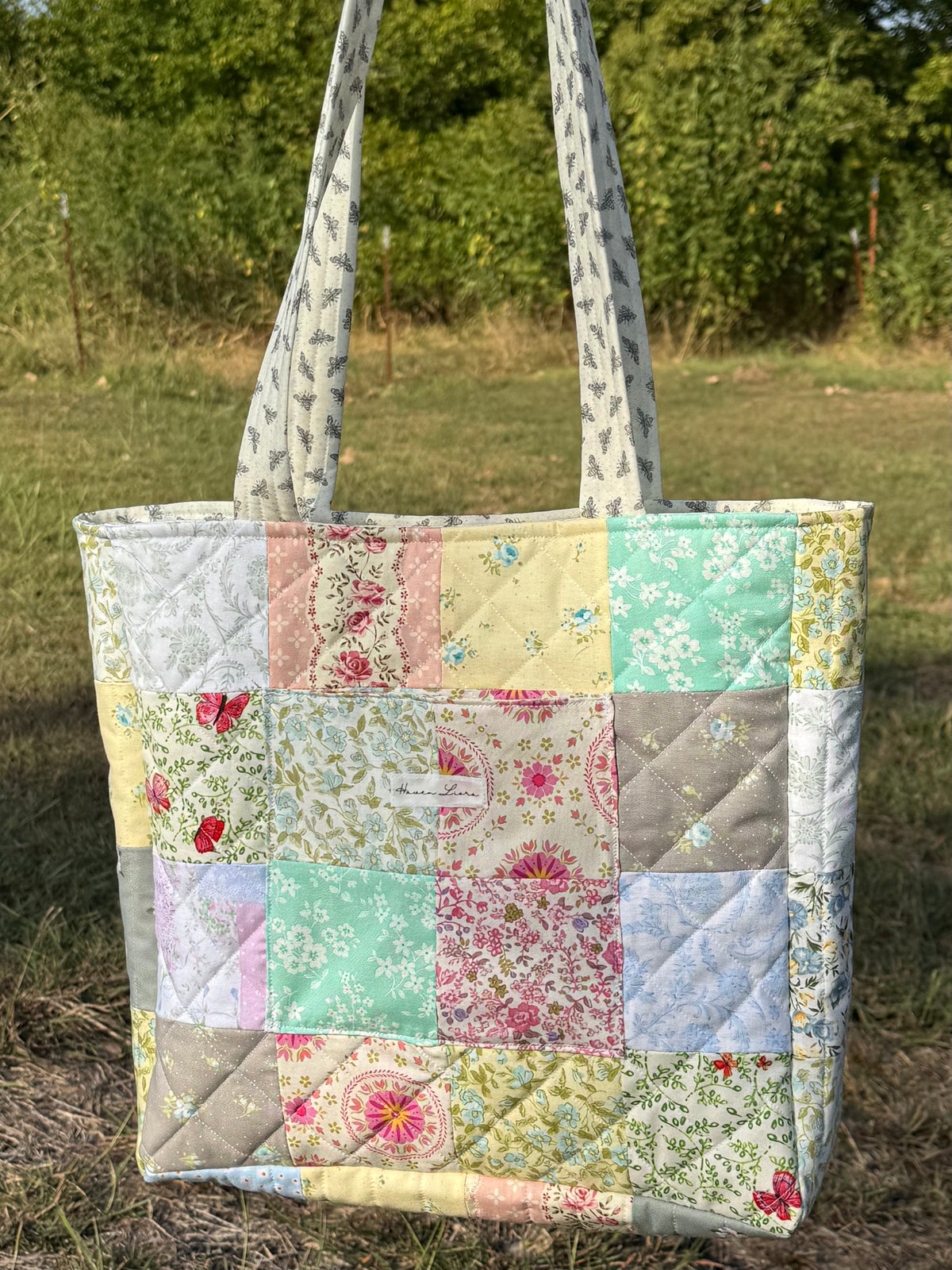 Cottage Patchwork Tote front view showing full pastel patchwork exterior with Haven Liora label